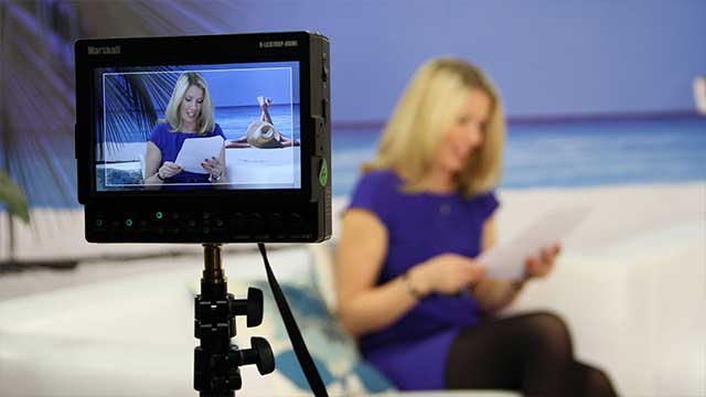 Woman reading script on television set recording