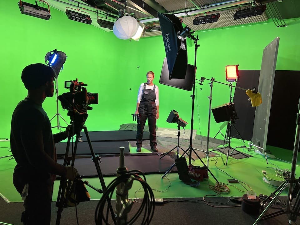 Film crew working in infinity cove green screen studio.