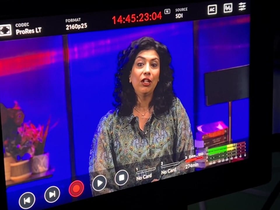 Woman speaking on camera in studio setting