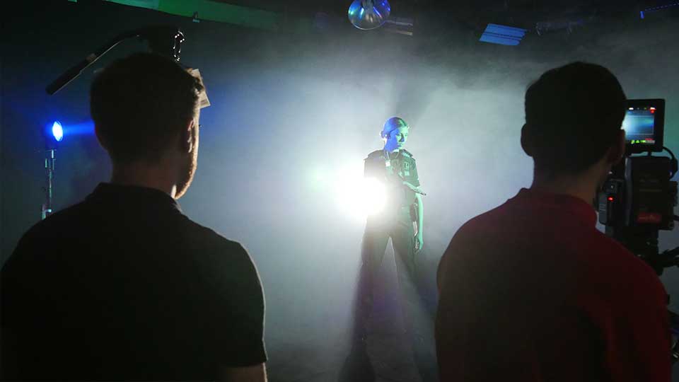 Film crew recording with bright spot lights in blackout studio Manchester