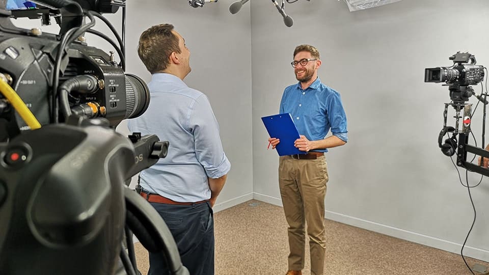 Two men filming in a professional studio