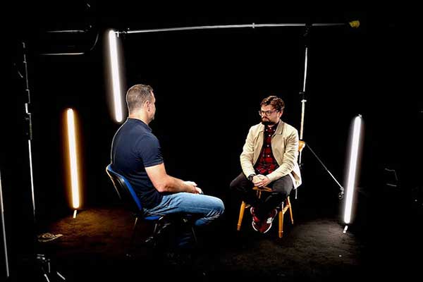 Two men discussing under professional interview lighting.