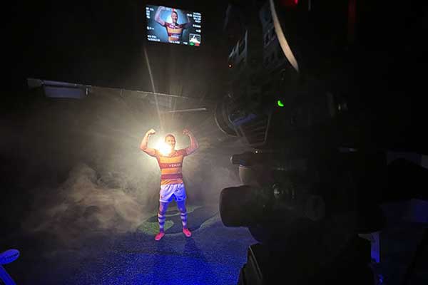 Soccer player posing under dramatic studio lighting
